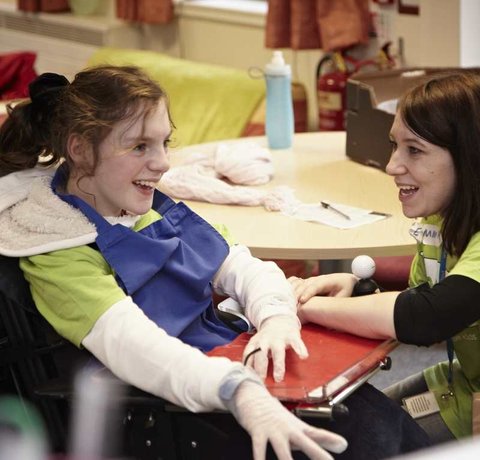 A Whizz Kidz staff member chats to a young wheelchair user