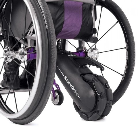 A Smart Drive power add-on attached to the back of a manual wheelchair