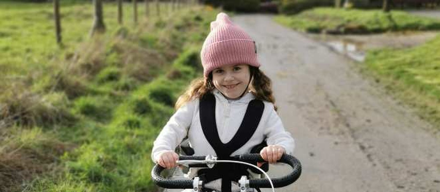 Carmella smiles as she uses her awesome pink trike